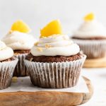 Straight on shot of hummingbird cupcakes sitting on a cutting board.