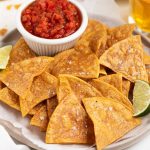 Gluten-Free baked tortilla chips with a side of salsa and beer.