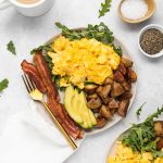 All ingredients for one pan breakfast arranged on a plate with a cup of coffee on the side.