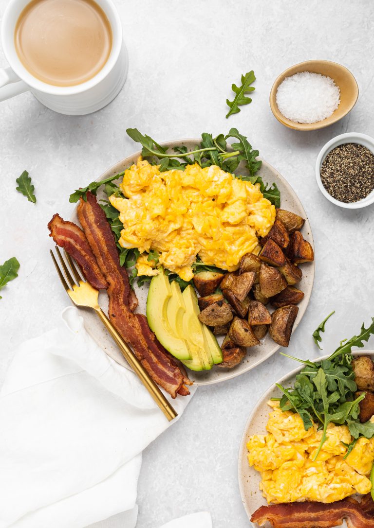All ingredients for one pan breakfast arranged on a plate with a cup of coffee on the side.