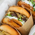 close up image of caramelized onion burgers in a baking pan