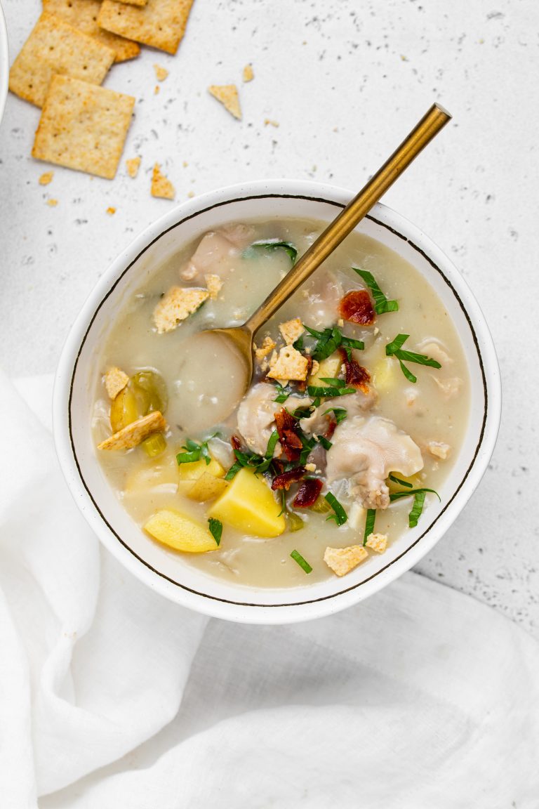 overhead image of a bowl of dairy-free clam chowder with gluten-free crackers on the side