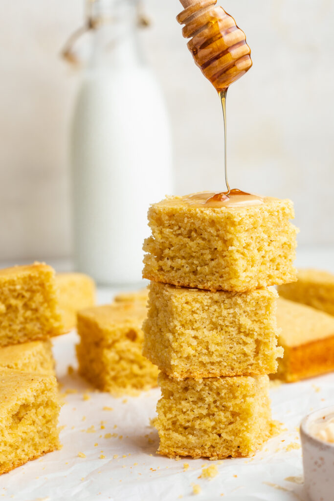 honey being drizzled over stacked gluten-free cornbread