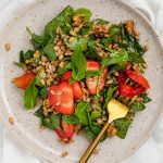 overhead image of strawberry spinach salad on a plate with a fork
