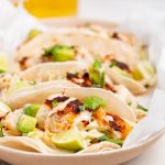 air fryer fish tacos on a plate with beer on the side