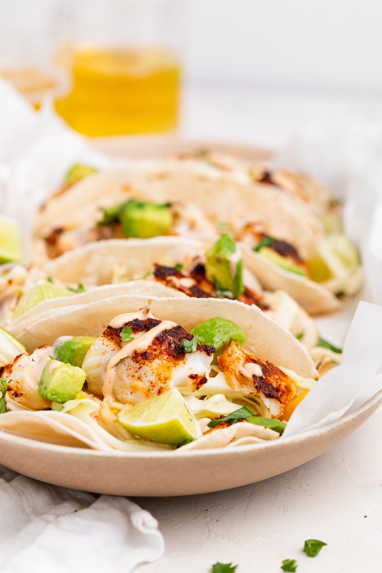 air fryer fish tacos on a plate with beer on the side