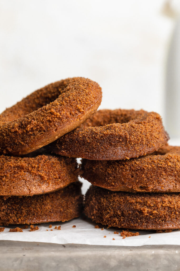 close-up image of healthy vegan apple cider donuts stacked on top of each other.