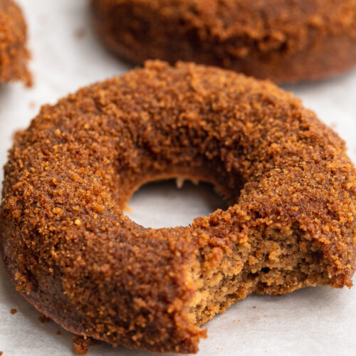 close-up image of a healthy vegan apple cider donut with a bite taken out.