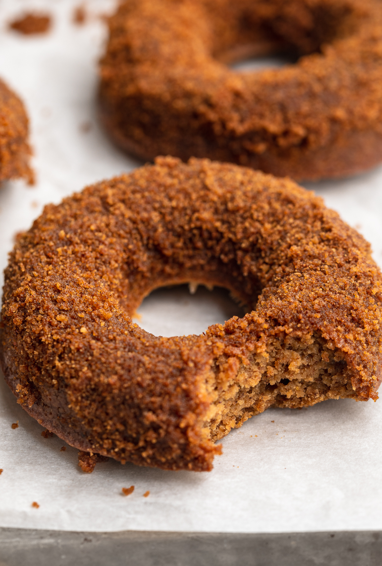 close-up image of a healthy vegan apple cider donut with a bite taken out.