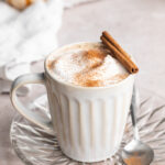 a healthy vegan pumpkin spice latte with a cinnamon stick on top.