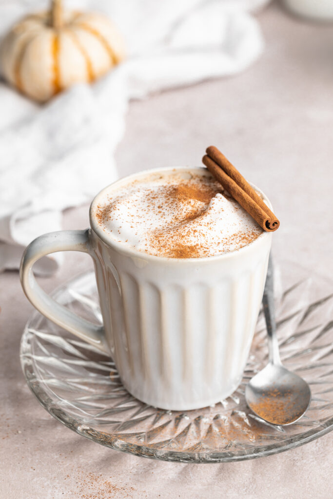 a healthy vegan pumpkin spice latte with a cinnamon stick on top.
