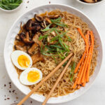 close-up overhead image of spicy ramen in a bowl with chopsticks