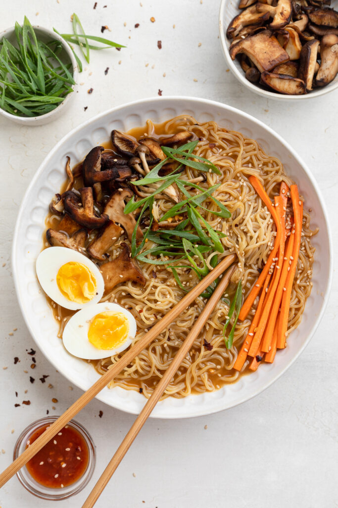 close-up overhead image of spicy ramen in a bowl with chopsticks
