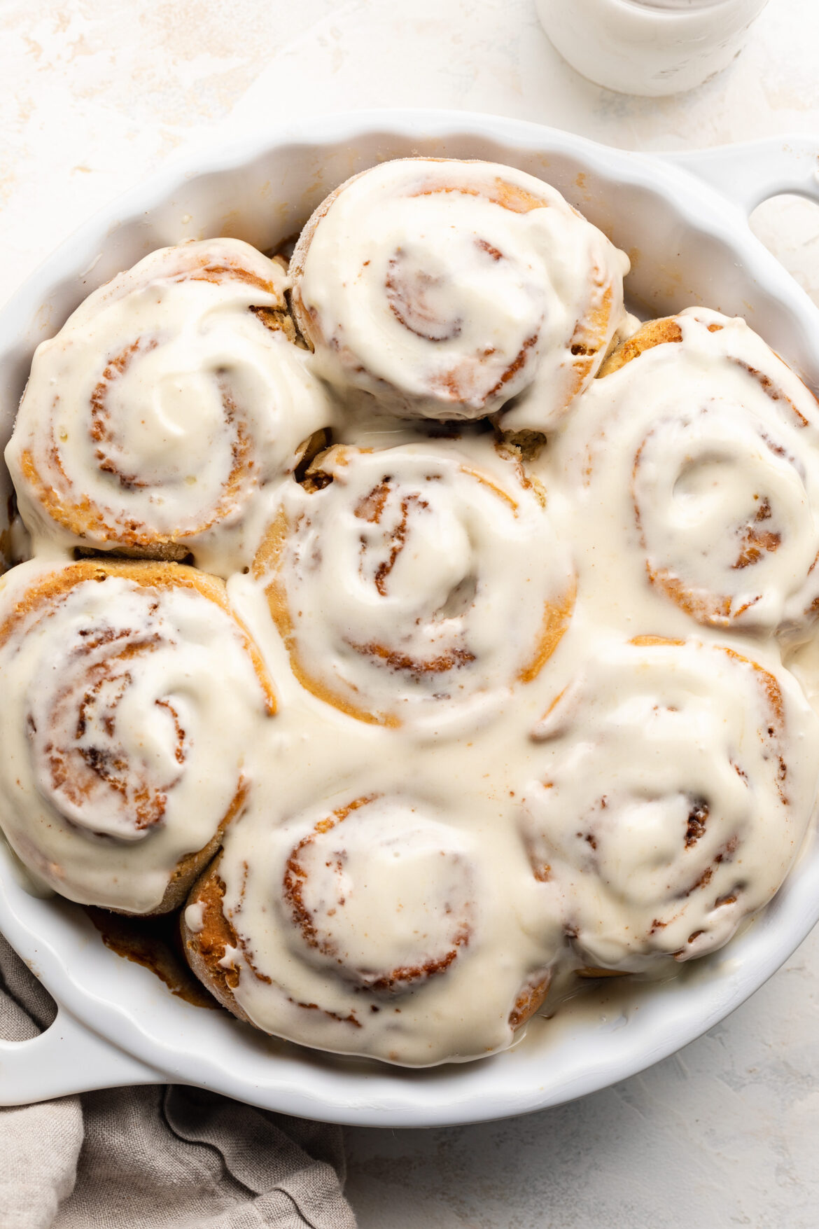 The BEST Fluffy Gluten-Free Cinnamon Rolls Overhead image of gluten-free cinnamon rolls in a baking dish with cream cheese frosting on top.