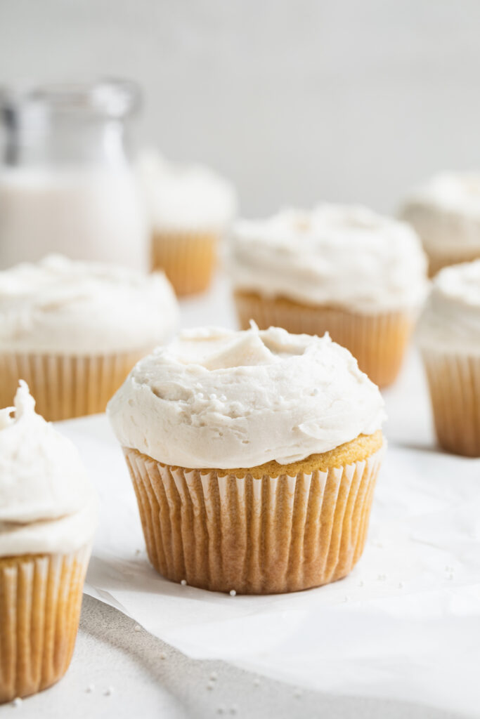 gluten-free cupcakes with vanilla frosting and white sprinkles
