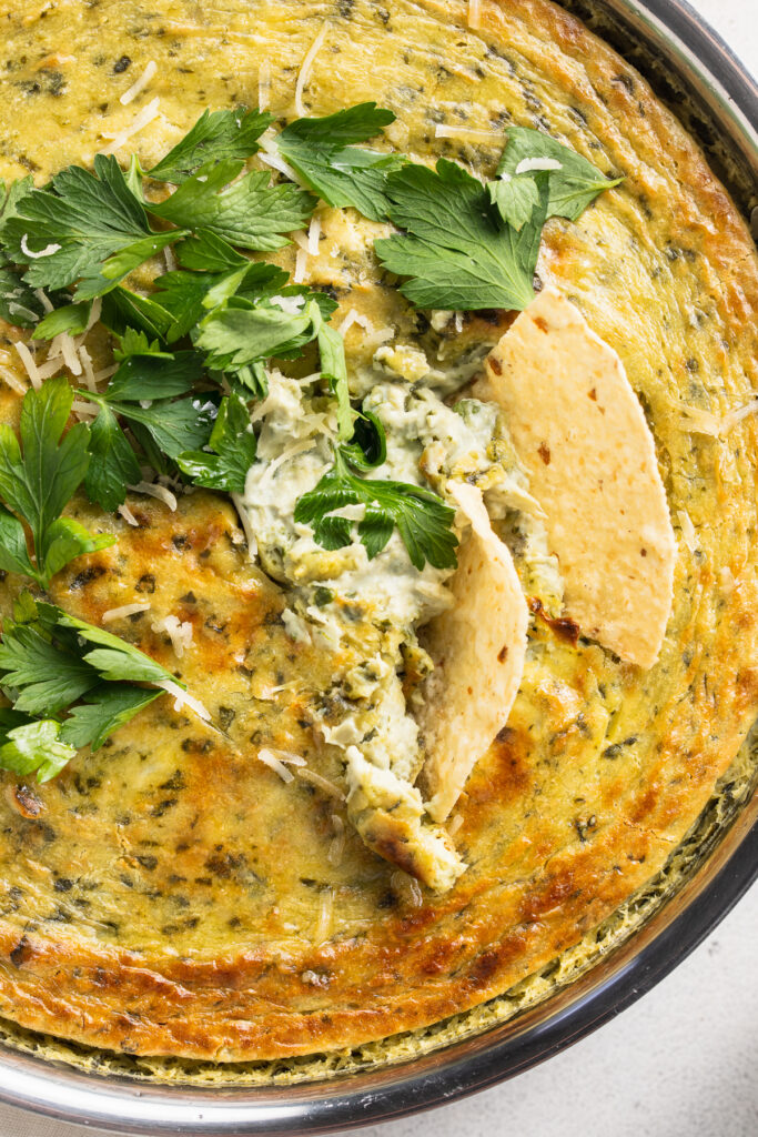 close-up image of vegan spinach artichoke dip with chips