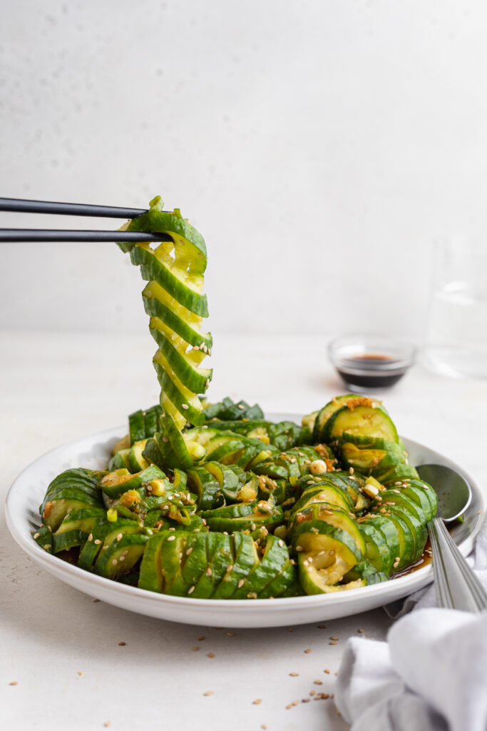spiralized cucumber being lifted off a plate of asian cucumber salad