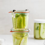 two jars of pickles stacked on top of each other.