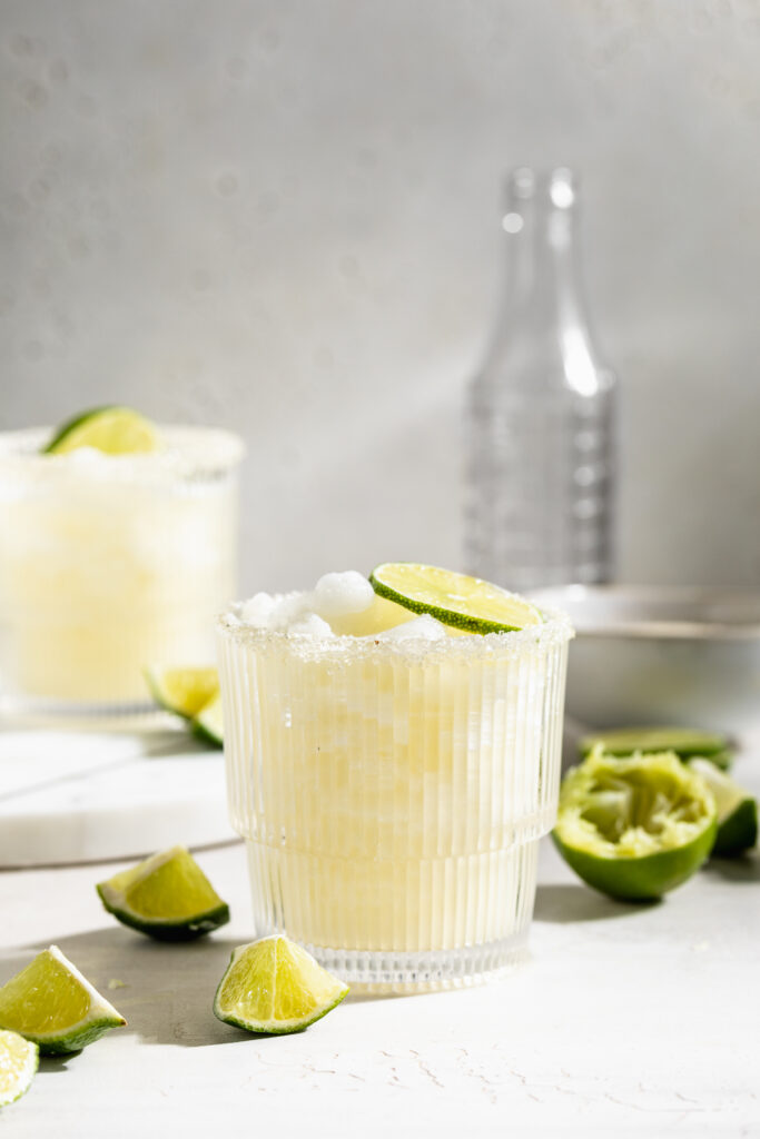 two frozen daiquiris with fresh limes on the side