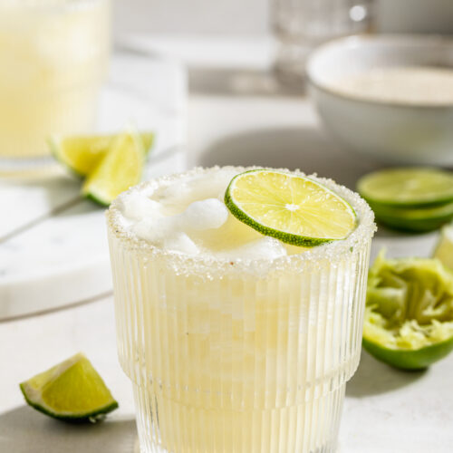 frozen daiquiri with fresh limes on the side.