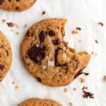 overhead image of an almond flour chocolate chip cookie with a bite taken out.