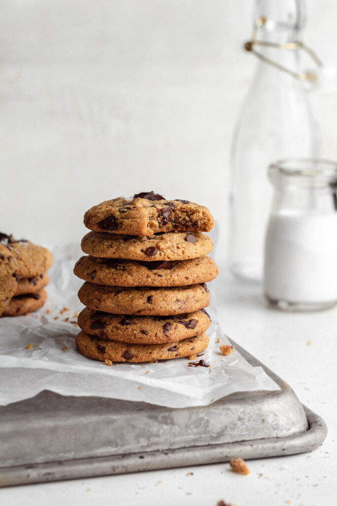 a stack of almond flour chocolate chip cookies with milk on the side.