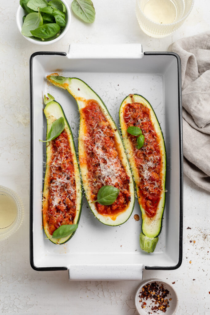 overhead image of zucchini boats in a baking dish.