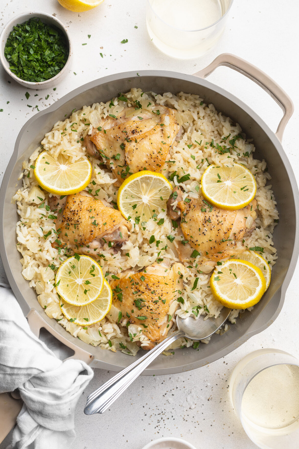 One-Pan Chicken and Rice Recipe overhead image of chicken and rice in a pan with lemon slices on top.