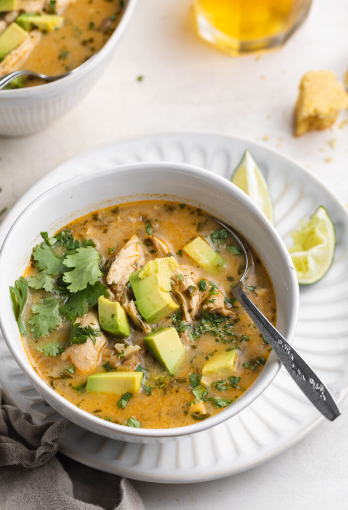 Instant Pot white chicken chili in a bowl with lime wedges on the side.