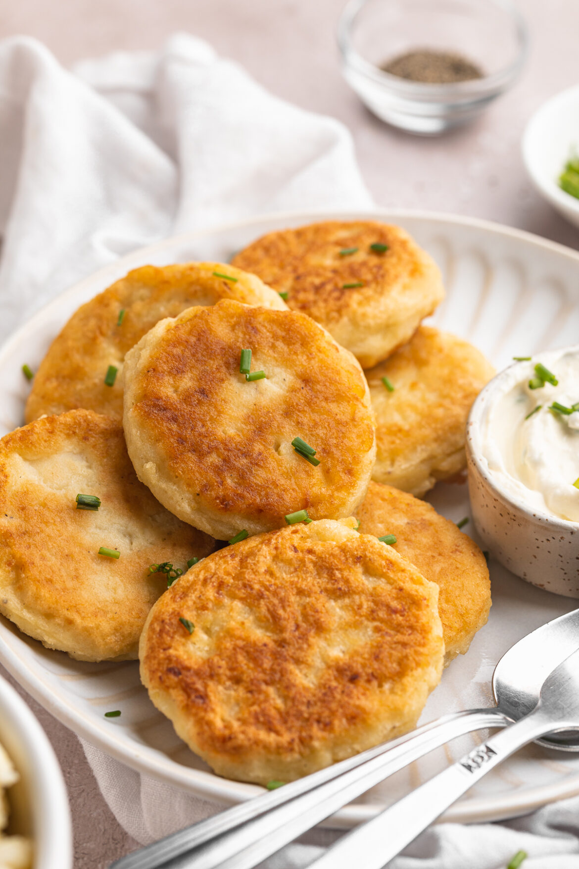 Leftover Mashed Potato Cakes with Chive-Onion Dip close-up image of mashed potato cakes on a plate.