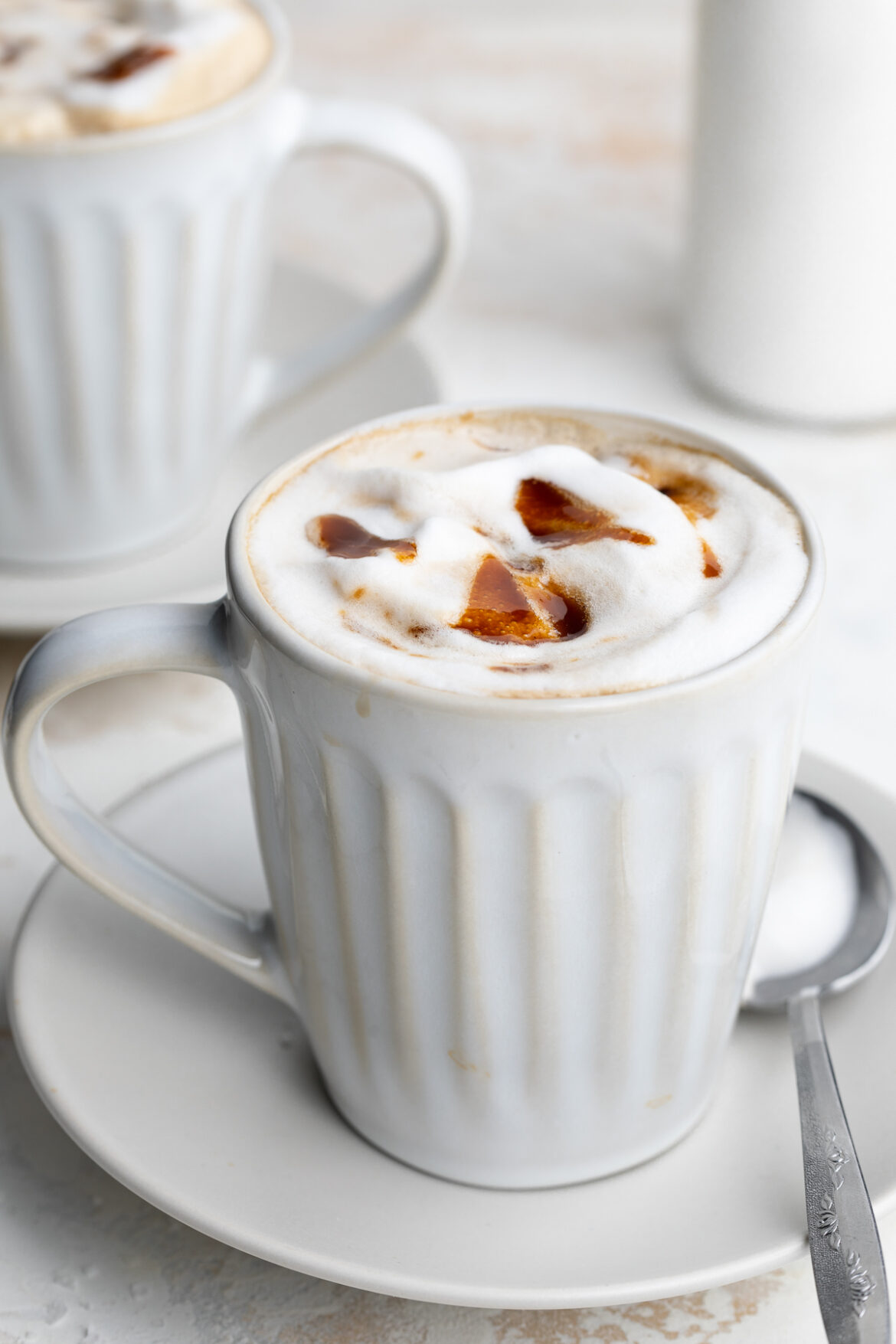 Healthy (& vegan!) Caramel Brulée Latte healthy caramel brulée latte in a mug with a spoon on the side.