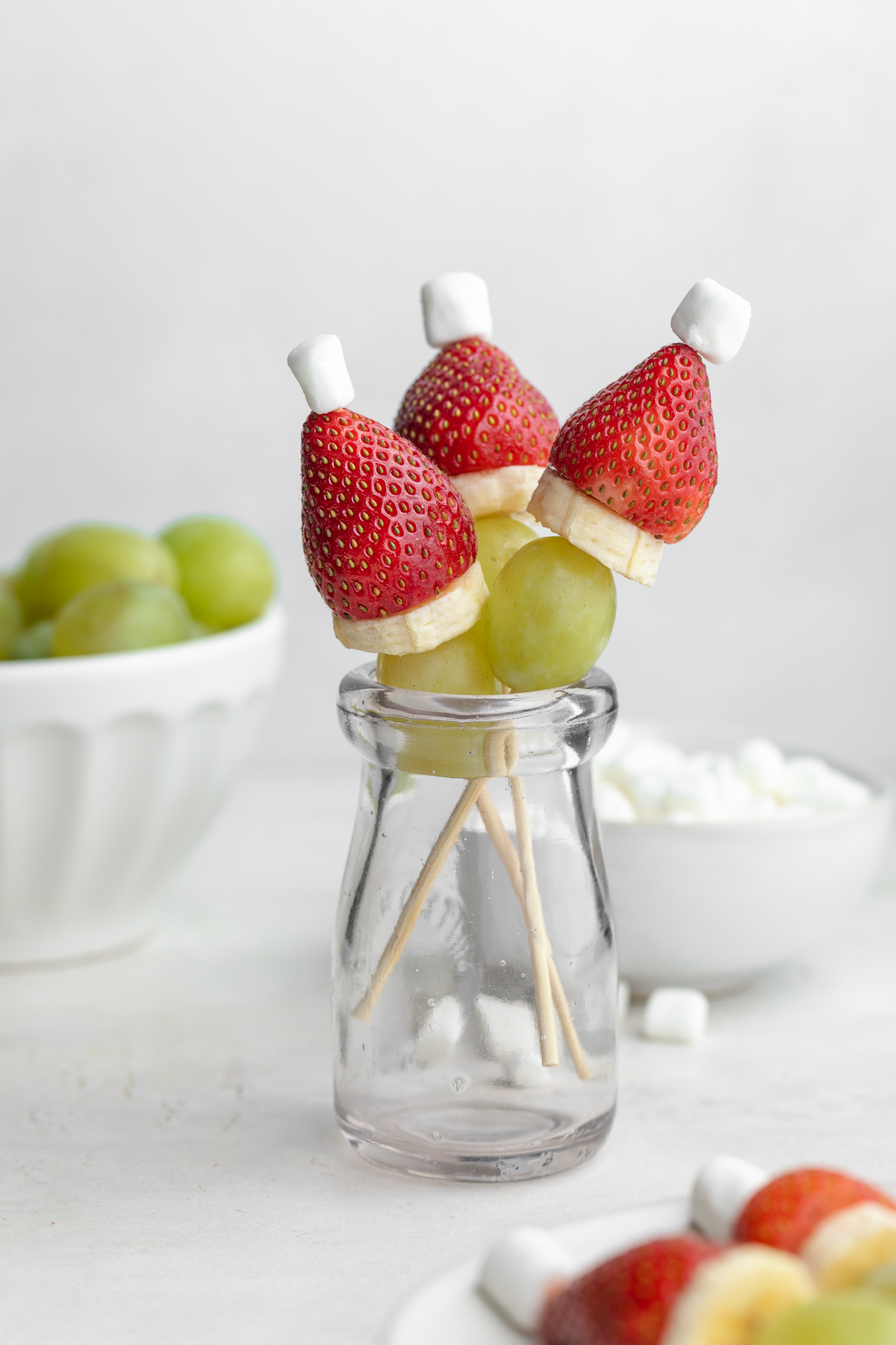 grinch fruit kabobs in a glass, standing upright