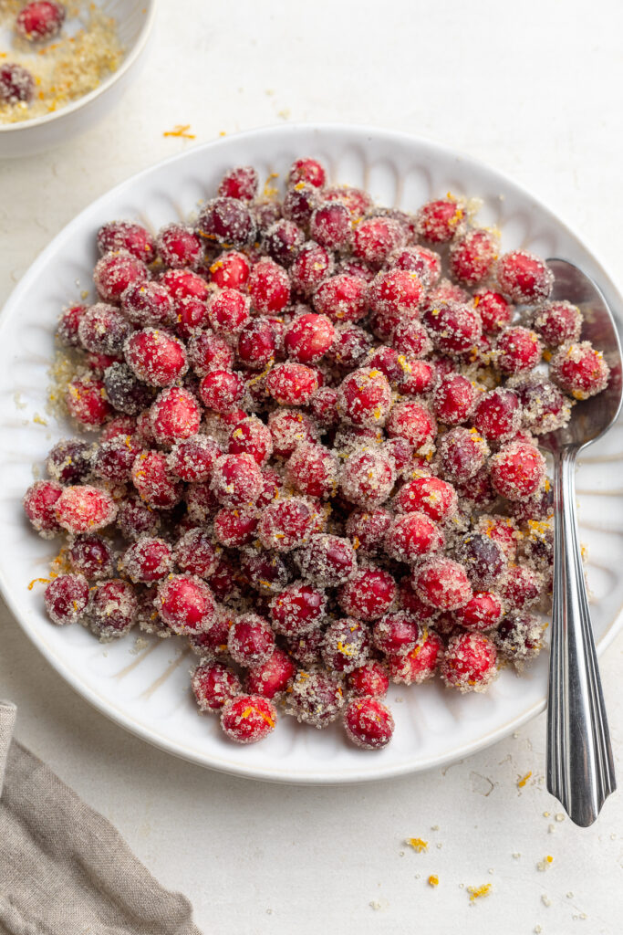 sugared cranberries on a plate with a spoon