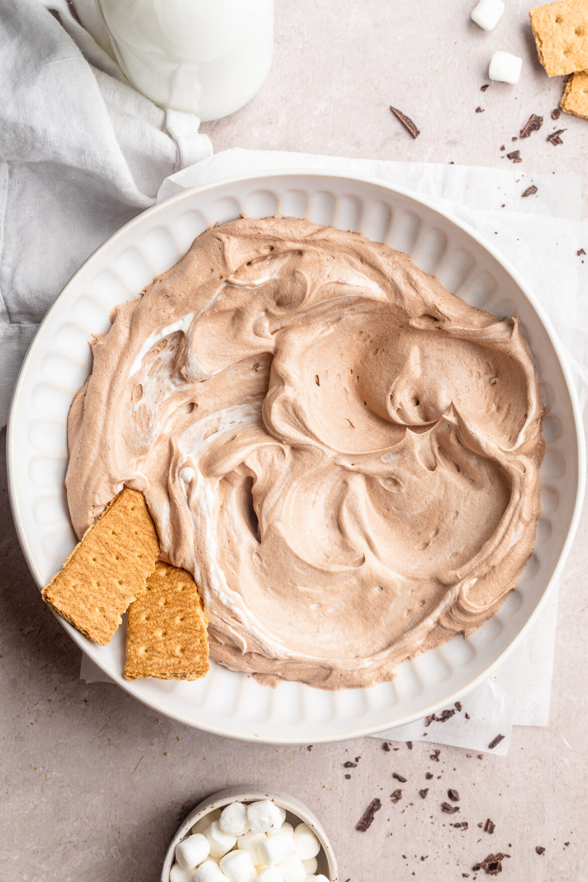 3-Ingredient Vegan Hot Chocolate Dip overhead image of vegan hot chocolate dip in a bowl with graham cracker, mini marshmallows, and chopped chocolate on the side.