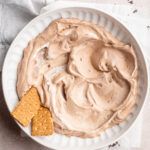 overhead image of vegan hot chocolate dip in a bowl with graham cracker, mini marshmallows, and chopped chocolate on the side.