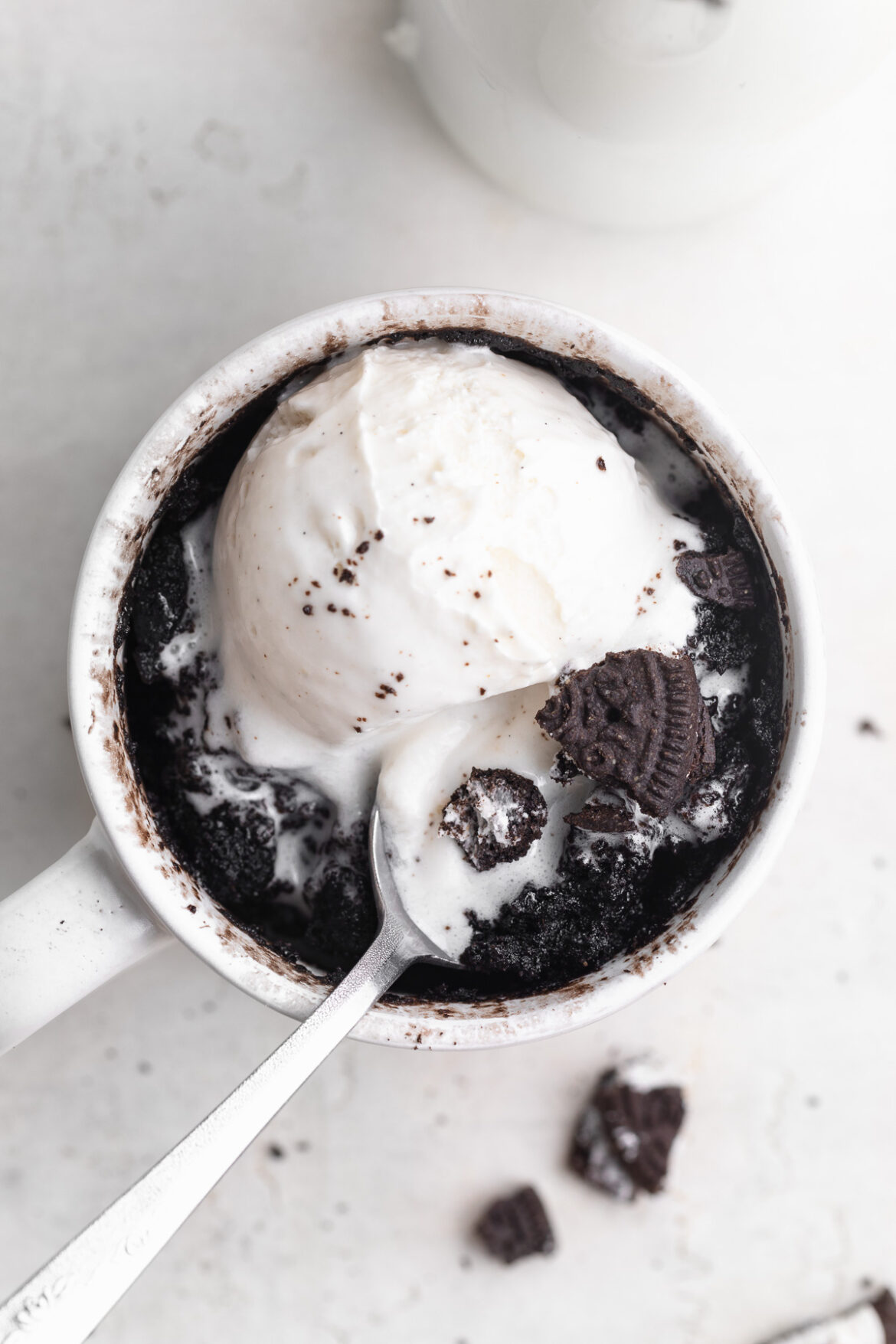 3-Ingredient Oreo Mug Cake overhead image of oreo mug cake with a scoop of vanilla ice cream on top.