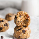 Two cookie dough dates bites stacked on top of each other.