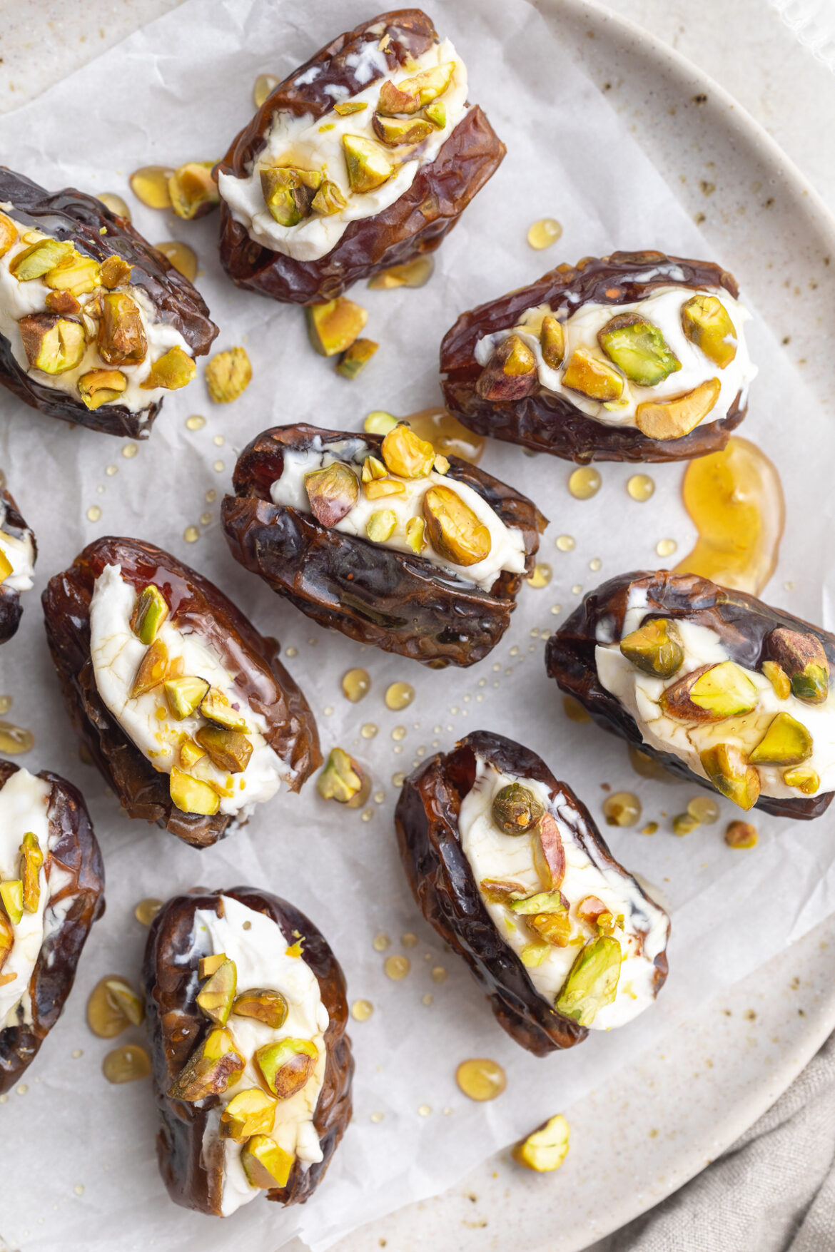 Stuffed Dates with Cream Cheese, Pistachios, and Honey close-up overhead image of stuffed dates with cream cheese, pistachios, and honey.
