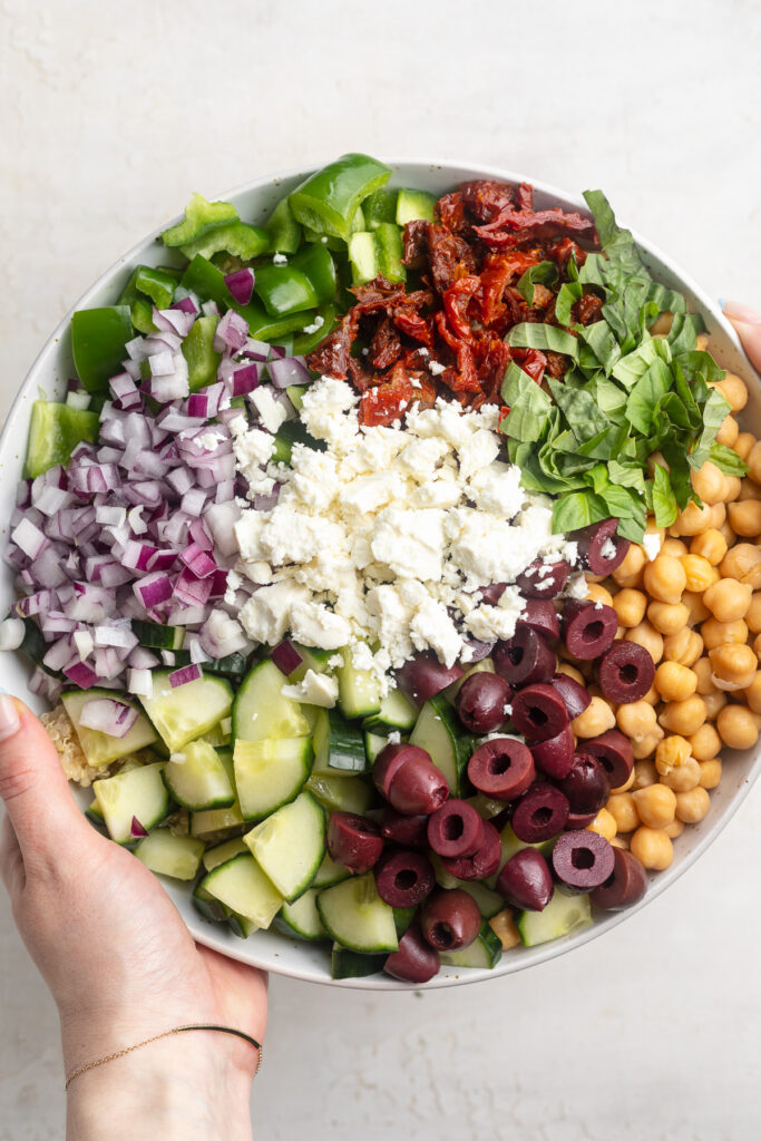mediterranean quinoa salad ingredients separated in a bowl.