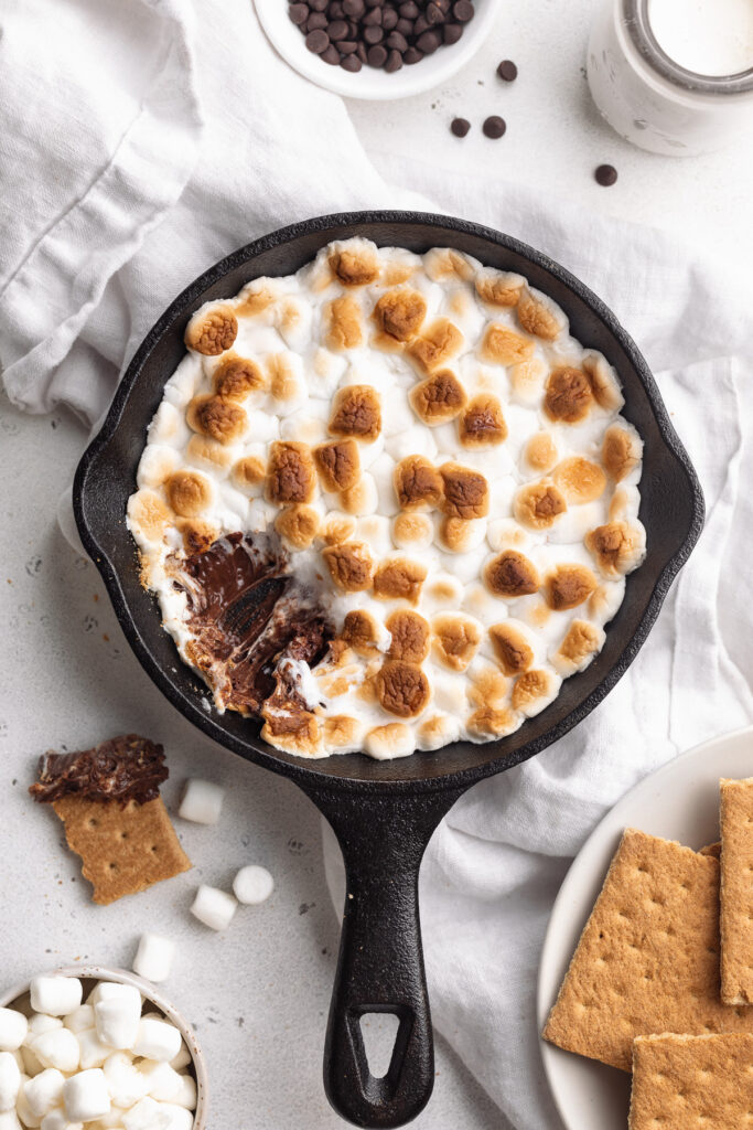 overhead image of s'mores dip with graham crackers and mini marshmallows on the side.