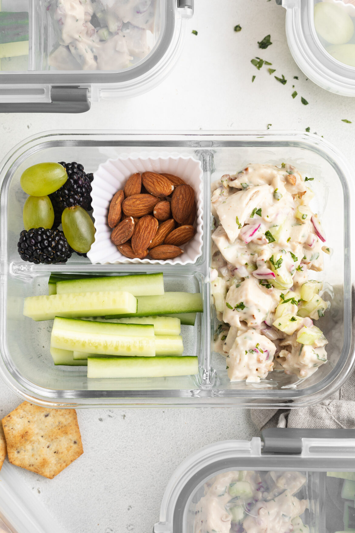 Meal Prep Chicken Salad Lunch Boxes overhead image of chicken salad lunch boxes with cucumbers, almond, grapes, and blackberries