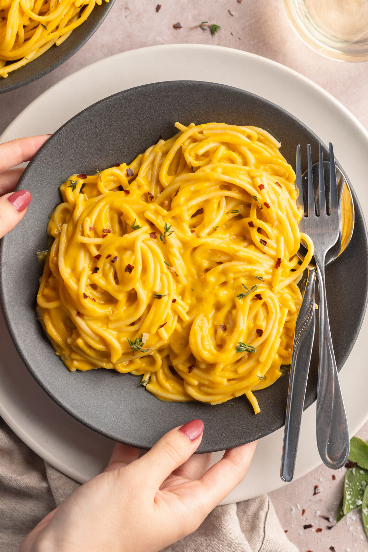 Creamy Butternut Squash Pasta (vegan!) Placing down a bowl of vegan creamy butternut squash pasta.