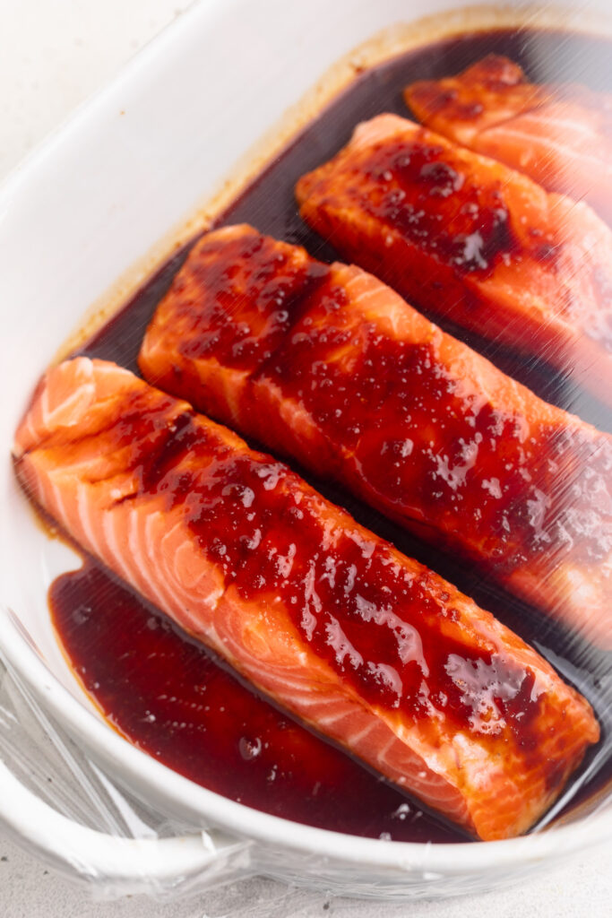 salmon fillets in a baking dish with honey teriyaki sauce