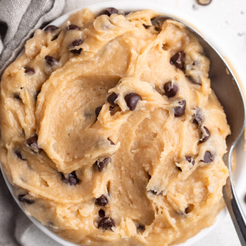 overhead image of gluten free edible cookie dough in a small dish with a spoon.