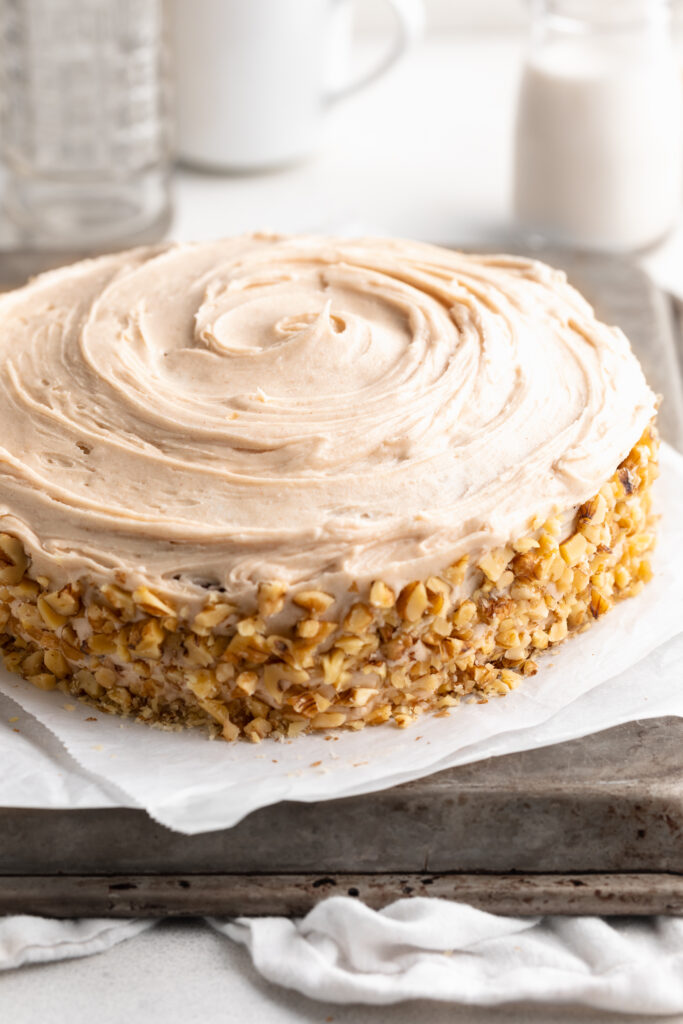 gluten free and dairy free carrot cake with cinnamon cream cheese frosting on a baking sheet.