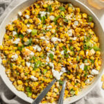 overhead image of Mexican street corn salad in a large serving dish with fresh cilantro on the side.