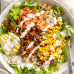 overhead image of taco bowls with cilantro lime crema drizzled on top