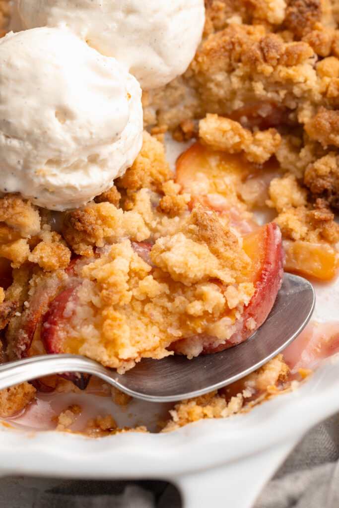 close up image of 4 ingredient peach cobbler in a baking dish.