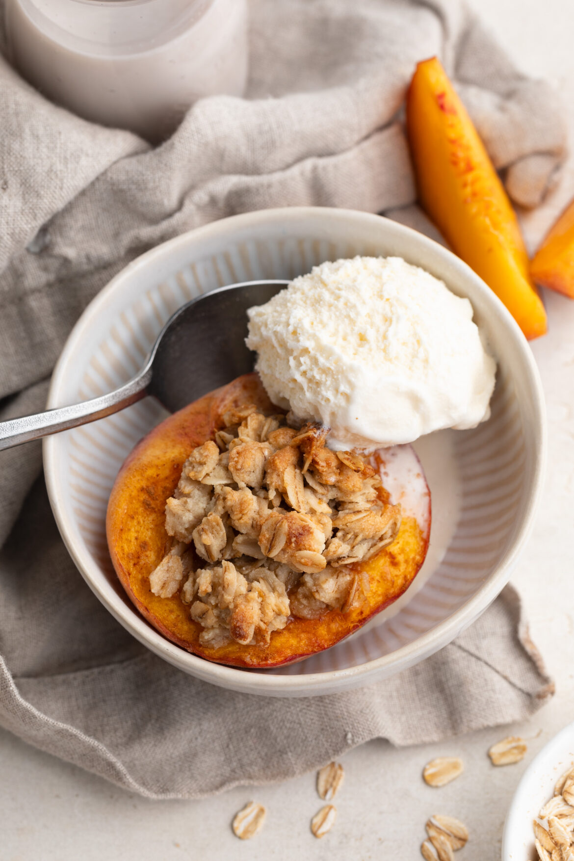 Healthy Single Serve Peach Crisp (vegan & gluten-free!) single serve peach crisp dessert in a bowl with a scoop of vanilla ice cream.