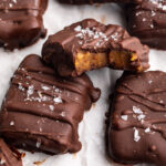 date caramels on a plate with flaky sea salt on top.